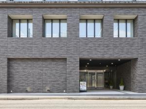 a brown brick building with a storefront at Shizutetsu Hotel Prezio Hakataekimae in Fukuoka