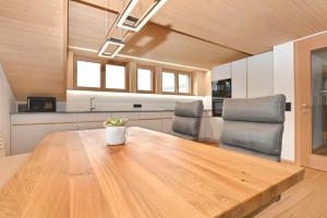 a large wooden table in a kitchen with two chairs at GebirgsImker-Apartment in Egg