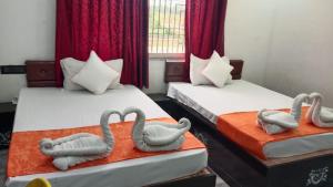 two beds with swans on them in a room at Hotel Royal Orbit in Rajauli