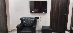 a black chair and a television on a wall at Hotel Royal Orbit in Rajauli