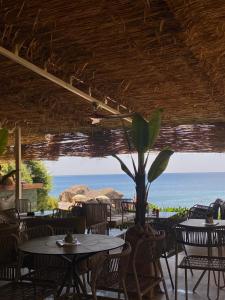 a restaurant with tables and chairs and a view of the ocean at Sobe-apartmani Gorica in Sutomore