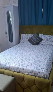 a bed in a bedroom with a blue curtain at Master Home in Baatsona