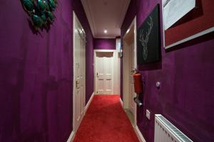 a hallway with purple walls and a red carpet at Edinburgh Central Drumdryan ApartHotel in Edinburgh