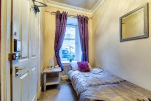 a small bedroom with a bed and a window at Edinburgh Central Drumdryan ApartHotel in Edinburgh