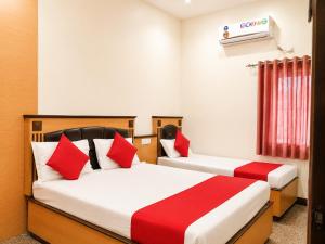 two beds in a room with red and white at Hotel Volga 2 in Mumbai