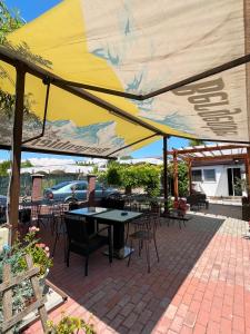 eine Terrasse mit Tischen und Stühlen unter einem gelben Sonnenschirm in der Unterkunft Casa Timerar in Venus + 116 Fotos