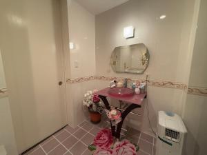a bathroom with a sink and a mirror at 美々パレスー沖縄の伝統文化に出会う琉球モダンな隠れ家ー in Itoman +11 photos