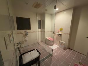 a bathroom with a shower with a toilet and a television at 美々パレスー沖縄の伝統文化に出会う琉球モダンな隠れ家ー in Itoman
