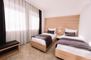 a bedroom with two beds and a television in it at Sobe B&M Livno in Livno