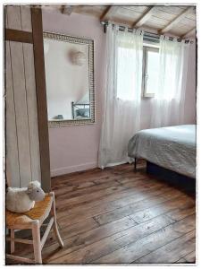 a bedroom with a bed and a mirror and a chair at Chambres d'hôtes " Casa della Felicità " in La Roche-sur-le-Buis
