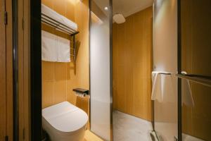 a small bathroom with a toilet and a shower at JI Hotel Beijing Guanganmen in Beijing +19 photos