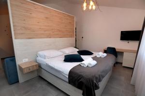a bedroom with a large bed with towels on it at Kapov's Rooms in Kaštela