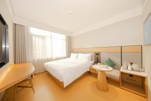 a hotel room with a bed and a table at JI Hotel Beijing Guanganmen in Beijing