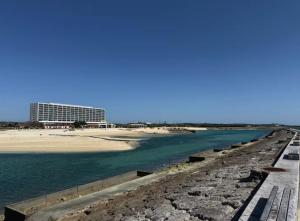 a view of a beach with a building in the background at 美々パレスー沖縄の伝統文化に出会う琉球モダンな隠れ家ー in Itoman