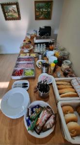 a long table with plates of food on it at Apartmány Miluška in Bešeňová