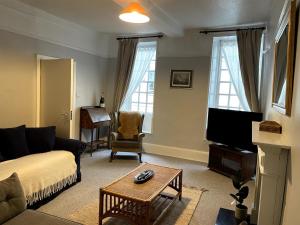 a living room with a couch and a tv at 2 Bed Period Flat with parking in Ross on Wye