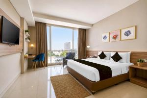 a hotel room with a bed and a large window at Sunday Hotel Antero Jababeka in Cikarang