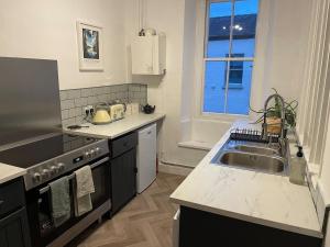 a kitchen with a sink and a stove at 2 Bed Period Flat with parking in Ross on Wye