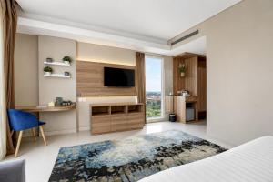 a bedroom with a bed and a television in a room at Sunday Hotel Antero Jababeka in Cikarang +42 photos