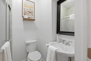 a white bathroom with a toilet and a sink at Casa Playa Long Beach in Long Beach