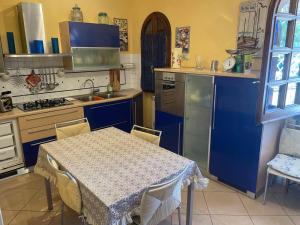 a kitchen with blue cabinets and a table with chairs at Sweet home Torre del lago in Torre del Lago Puccini