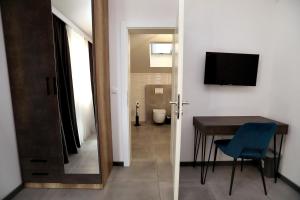 a room with a desk and a table with a blue chair at Kapov's Rooms in Kaštela