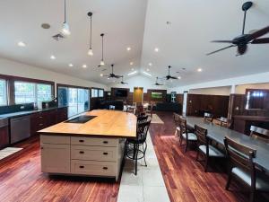 a large kitchen with wooden floors and a large island at Hale Halai in Hauula