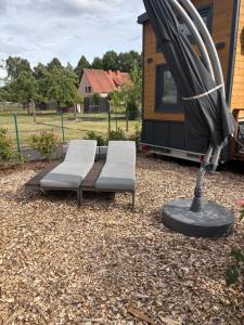 a couple of chairs and an umbrella in front of a house at KE-Tiny-Siedlung Haus Buddy in Oerlenbach