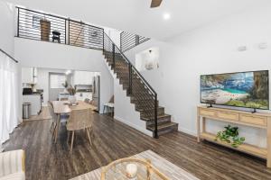 a living room with a staircase and a dining room table at Casa Playa Long Beach in Long Beach
