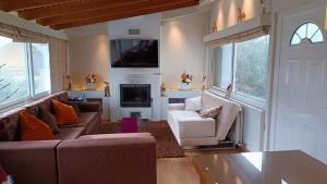 a living room with two couches and a fireplace at olivegrove in Sidari