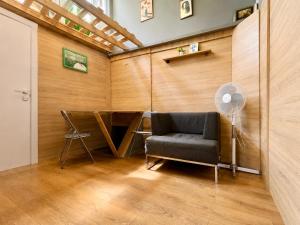 a room with a chair and a table and a fan at Mouse House in Chişinău