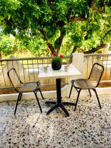 a white table and two chairs on a patio at Margianna Apartments1 in Káto Ássos