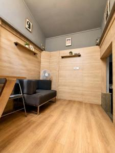a living room with a black couch and a wooden wall at Mouse House in Chişinău