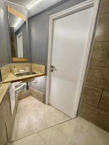 a bathroom with a white door and a sink at Mouse House in Chişinău