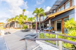 an outdoor deck of a house with palm trees at Hening Jimbaran in Jimbaran