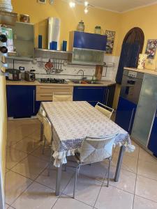 a kitchen with a table and some blue cabinets at Sweet home Torre del lago in Torre del Lago Puccini +3 photos