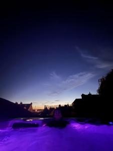 a person in a purple lighted swimming pool at night at Maison Saint Christophe in Le Mans