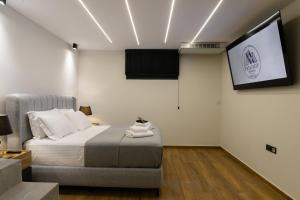a bedroom with a bed and a tv on the wall at Trilogy Resorts in Alexandroupoli