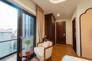 a living room with a chair and a large window at Olong Pho Co Hotel Ninh Binh in Kỳ Vĩ +3 photos