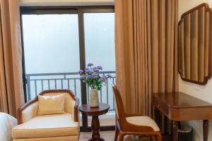 a hotel room with a desk and a chair and a table at Olong Pho Co Hotel Ninh Binh in Kỳ Vĩ