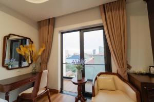 a living room with a window and a chair and a mirror at Olong Pho Co Hotel Ninh Binh in Kỳ Vĩ