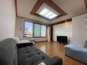 a living room with a couch and a television at BV House in Incheon