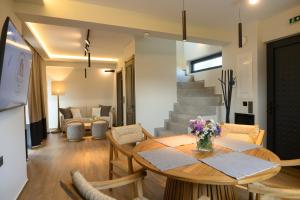 a living room with a table and chairs and a staircase at Trilogy Resorts in Alexandroupoli