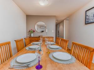 a dining room with a table with plates and wine glasses at Breakwater Views Apartment 2 Cabarita Beach in Cabarita Beach +5 photos