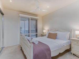 a bedroom with a white bed and a window at Breakwater Views Apartment 2 Cabarita Beach in Cabarita Beach