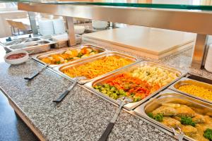 a buffet line with trays of different types of food at Jugendhaus St. Kilian in Miltenberg +16 photos