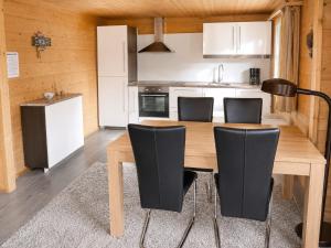 a kitchen with a wooden table and black chairs at Chalet in Wiler near Ski Lift & Views in Fiesch