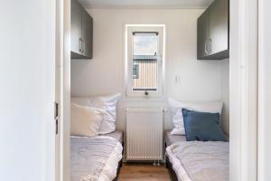 two beds in a small room with a window at Rapunzel in Dörverden