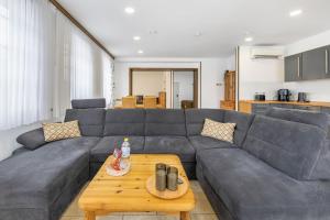a living room with a gray couch and a table at Ferienwohnung Ostermann in Plettenberg