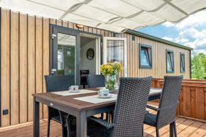 a tiny house with a table and chairs on a deck at Janes in Dörverden